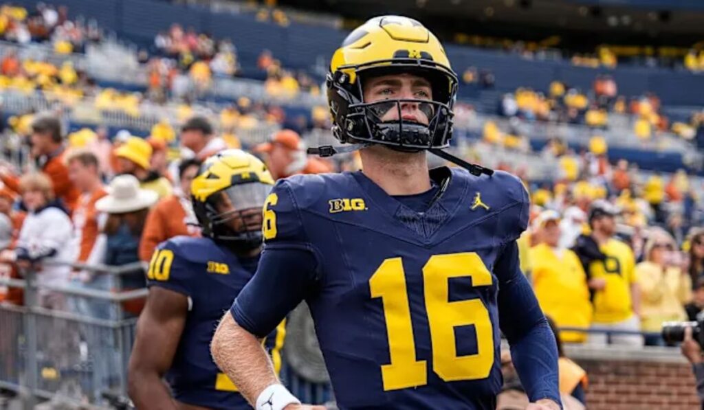 Report headline indicating that Michigan is expected to start a new quarterback in their upcoming game against Michigan State, highlighting the team's ongoing offensive challenges.