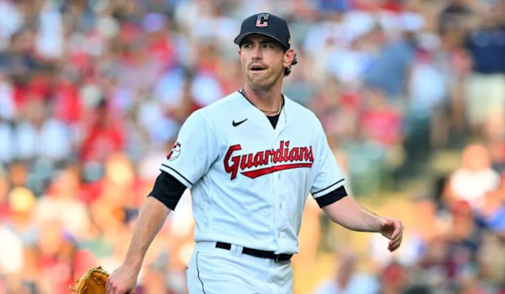 Shane Bieber pitching, with Detroit Tigers and Blue Jays logos overlaid