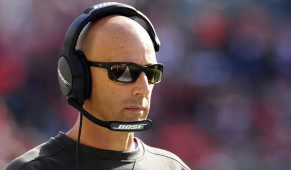 Jim Bajakian coaching on the sidelines during a Utah football game, focused on leading the Utes' offense as the newly appointed interim offensive coordinator.