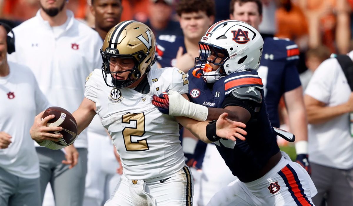 Players from Vanderbilt and Auburn in a tense moment during a football game, showcasing intense emotions and competitive spirit as they engage in a heated exchange on the field.