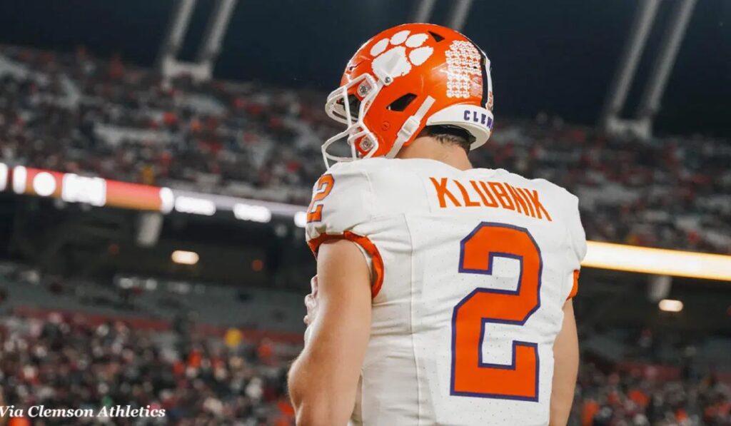 Image of Cade Klubnik, Clemson's quarterback, in action during a game, with intense focus on his face as he prepares to throw a pass.